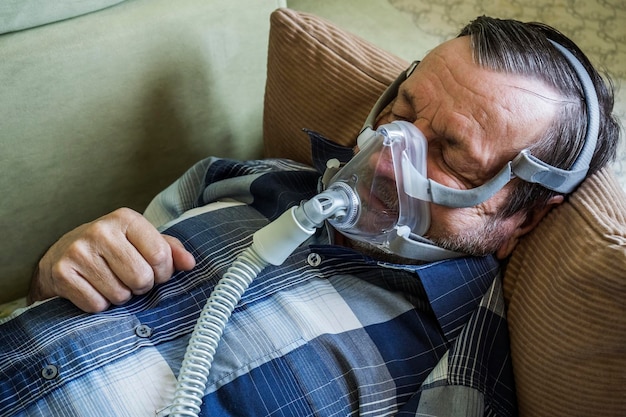 Photo un homme âgé avec le coronavirus covid-19 portant un masque à oxygène utilise la ventilation artificielle