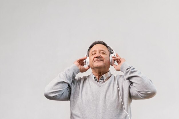 Homme âgé dans le salon portant un casque