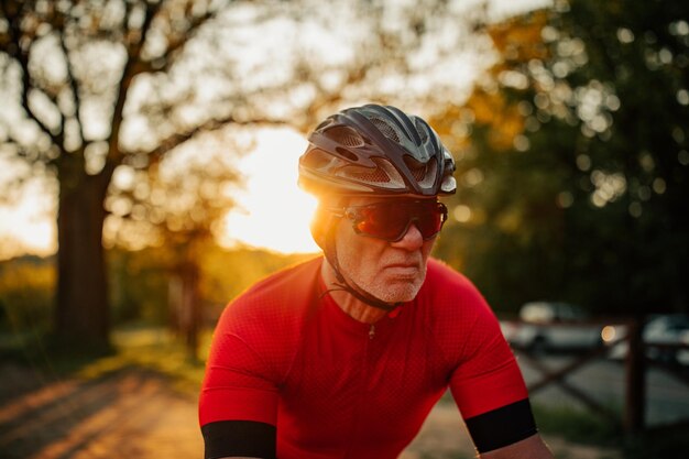 Homme âgé faisant du vélo à travers la forêt