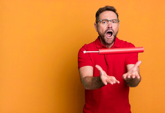 Homme d'âge moyen avec un concept d'entraîneur de sport de dynamite avec un ballon de football