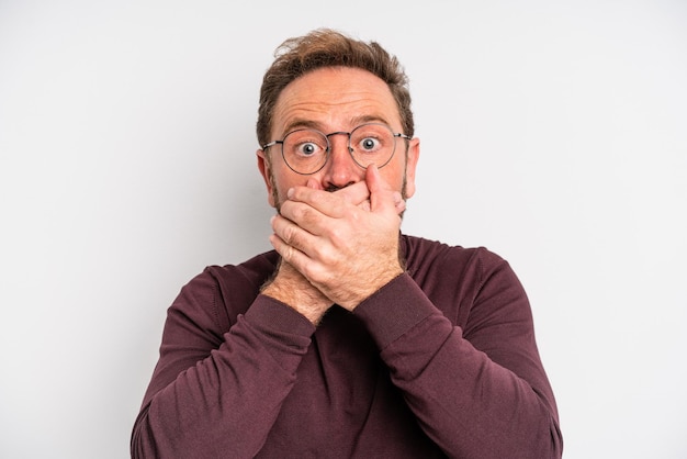 Homme d'âge moyen couvrant la bouche avec les mains avec un choqué