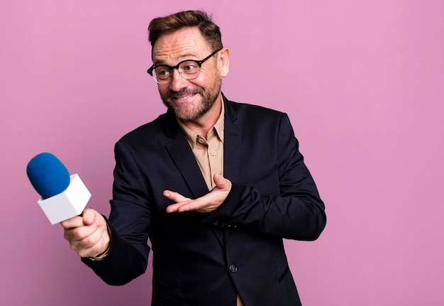 Homme d'âge moyen avec un journaliste de microphone ou concept de présentateur concept d'entraîneur de sport avec un ballon de football