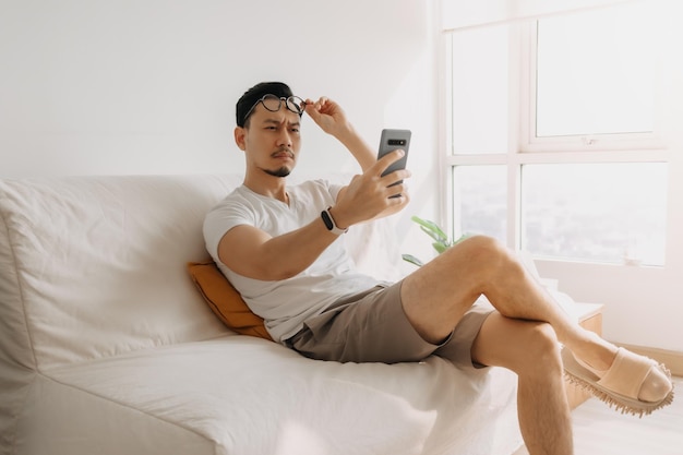 Un homme d'âge moyen avec une longue vue oculaire essaie de regarder le smartphone