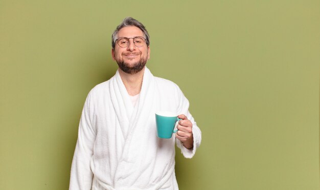 Homme d'âge moyen se réveillant avec une tasse de café