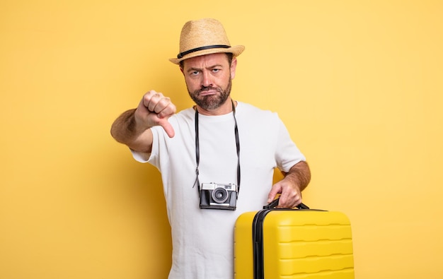 Homme d'âge moyen se sentant touristique croix, montrant les pouces vers le bas. concept de voyage