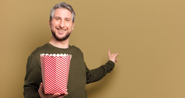 Homme d'âge moyen avec un seau de pop-corn