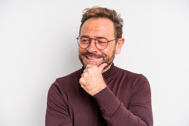 Homme d'âge moyen souriant avec une expression heureuse et confiante avec la main sur le menton