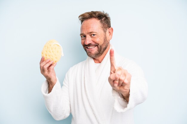 Homme d'âge moyen souriant fièrement et avec confiance faisant le numéro un. notion de douche