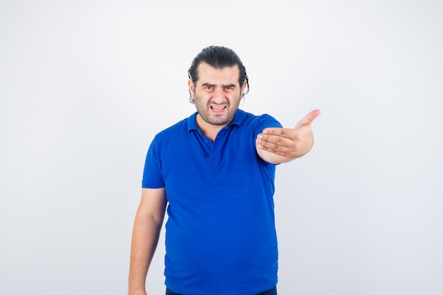 Homme d'âge moyen en t-shirt polo invitant à venir et à la vue de face en colère