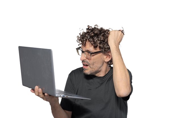 Homme d'âge moyen tirant ses cheveux et tenant un ordinateur portable sur un fond blanc
