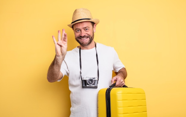 Homme d'âge moyen touriste souriant et sympathique montrant le concept de voyage numéro quatre