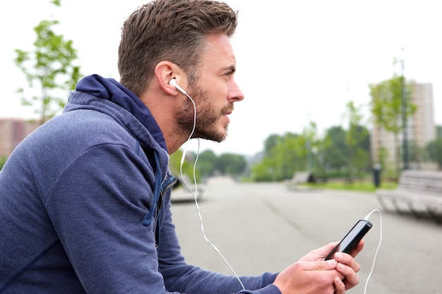 Homme d&#39;âge mûr actif assis et écoutant de la musique