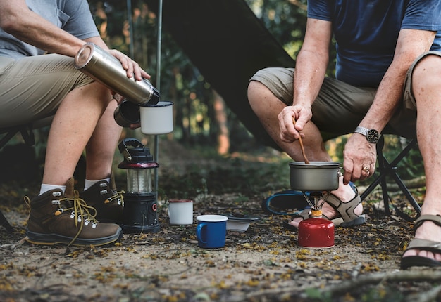 Homme d&#39;âge mûr cuisiner dans un camping