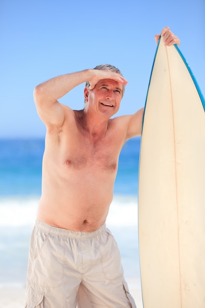 Homme d&#39;âge mûr avec sa planche de surf