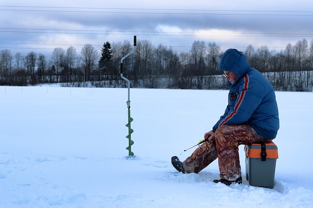 Un homme âgé a pêché en hiver sur le lac