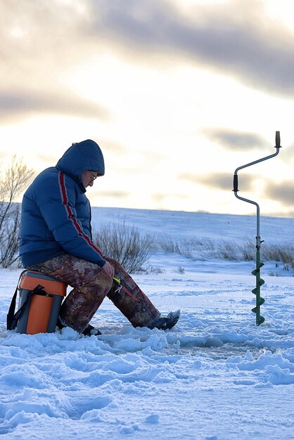 Un homme âgé a pêché en hiver sur le lac