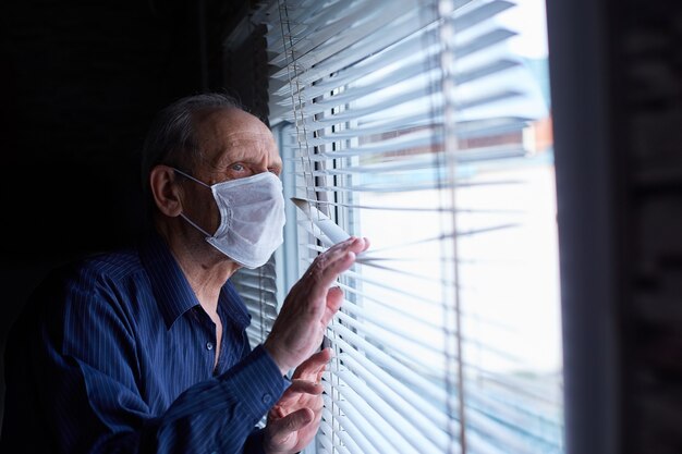 Un homme âgé portant un masque médical est en quarantaine et s'isolement