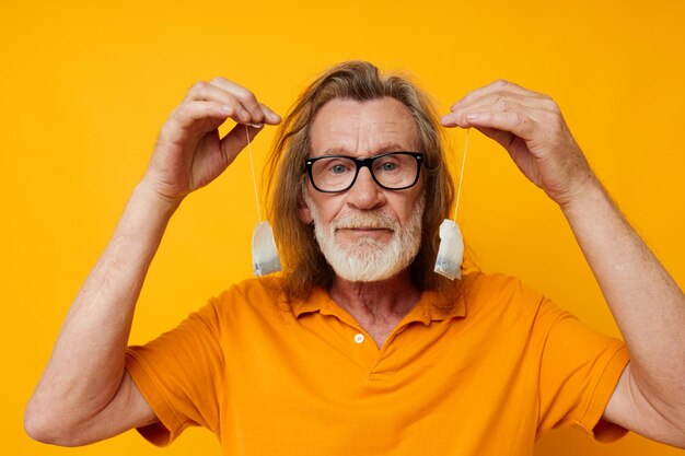 Homme âgé portant un t-shirt jaune sachets de thé