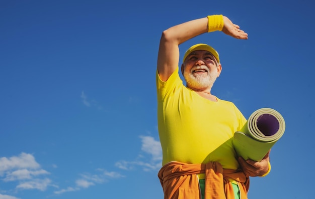 Homme âgé pratiquant des sports sur fond de ciel bleu sport sain et sport grand-père pensione