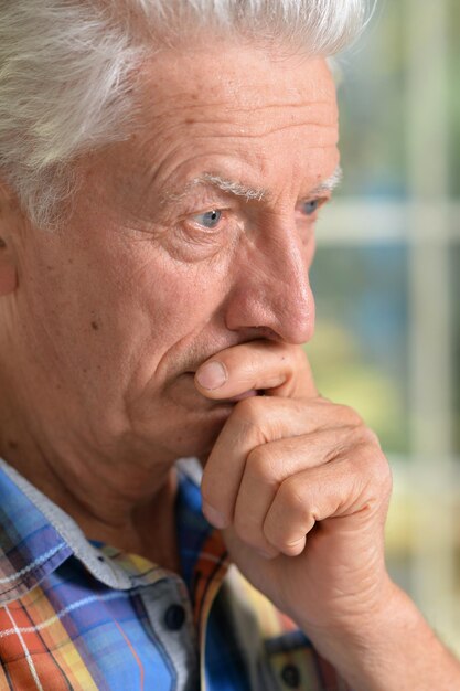 Homme âgé réfléchi avec la main sur le menton