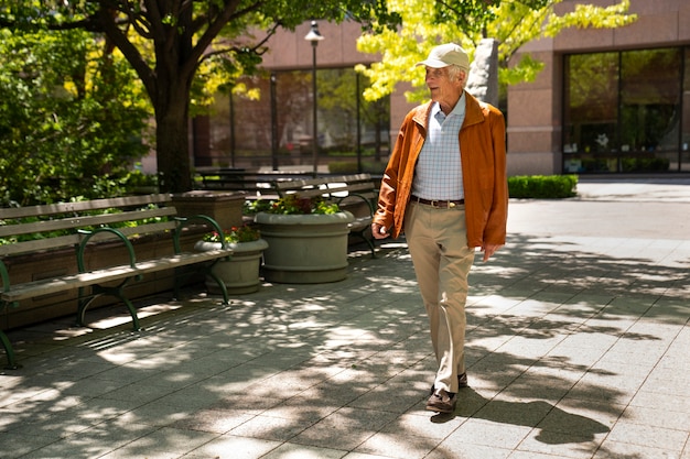 Homme âgé se promenant à l'extérieur de la ville