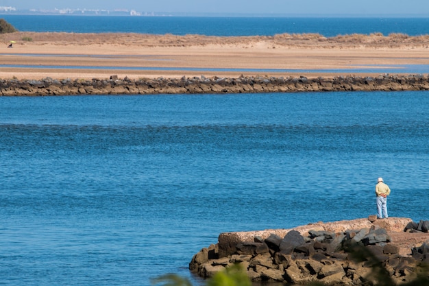 Photo un homme âgé solitaire regarde la mer