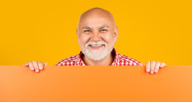 Homme âgé souriant avec espace de copie sur une bannière vierge présentant le produit