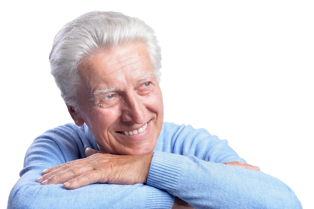 Homme âgé souriant posant sur fond blanc