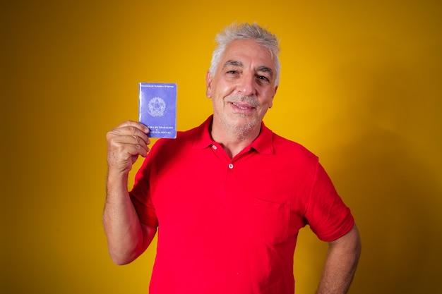Homme âgé tenant une carte de travail brésilienne