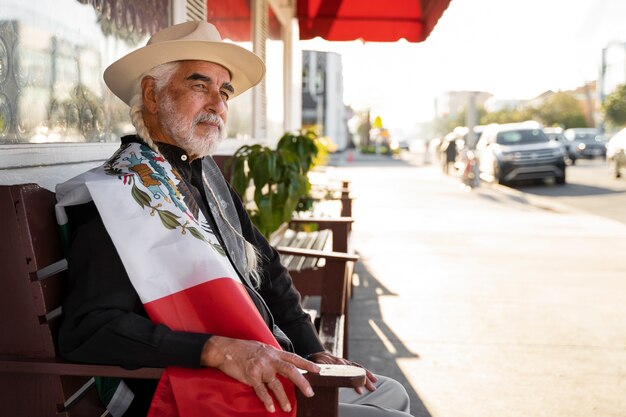 Homme âgé tenant la vue latérale du drapeau mexicain