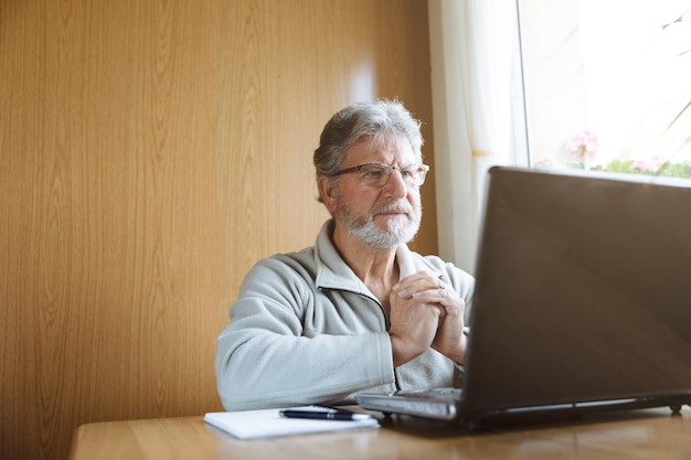 Homme âgé utilisant un ordinateur portable à la maison