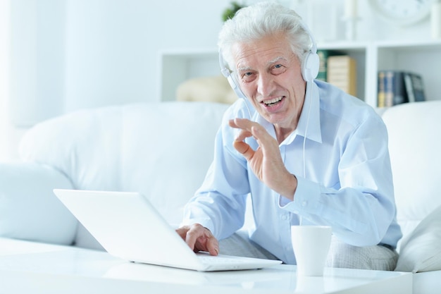 Homme âgé utilisant un ordinateur portable à la maison