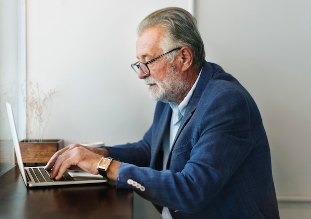 Un homme âgé utilise un ordinateur portable