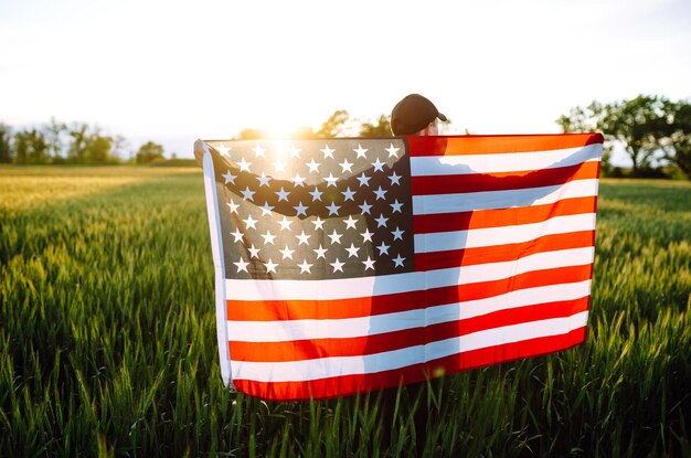 Photo homme agitant le drapeau américain patriot lève le drapeaux national américain jour de l'indépendance 4 juillet