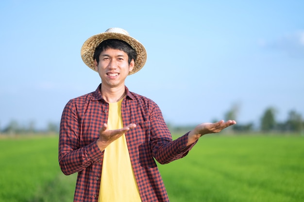 Homme agriculteur asiatique debout et lever la main à la ferme de riz