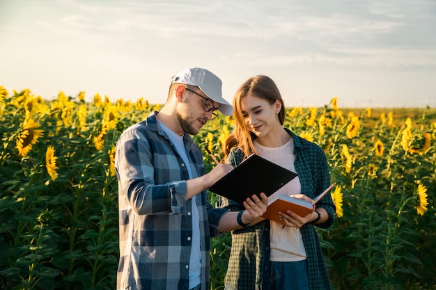 Homme agronome enseignant jeune étudiant dans le champ de tournesol