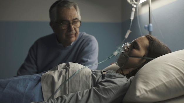 Homme aidant sa jeune fille à l'hôpital