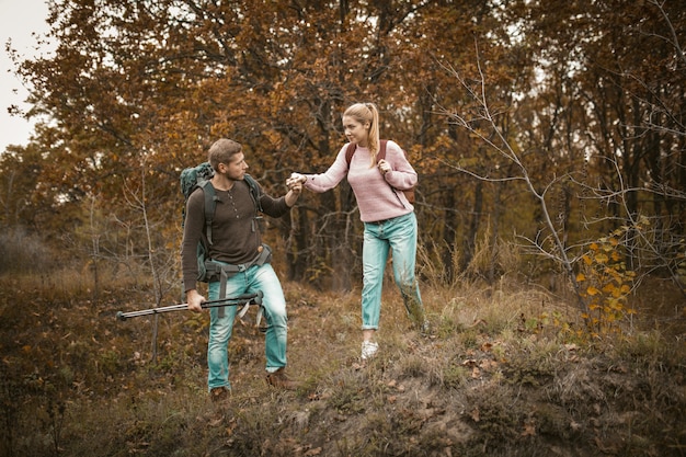 Un homme aide sa femme à descendre la colline