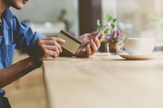 Photo homme à l'aide de smartphone et carte de crédit mobile. achats en ligne.