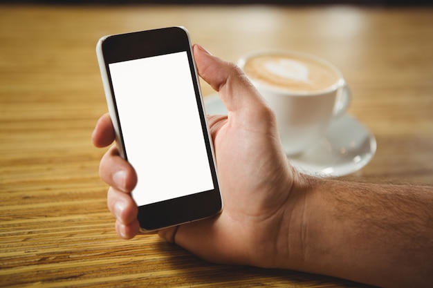 Homme à l&#39;aide de son smartphone avec café