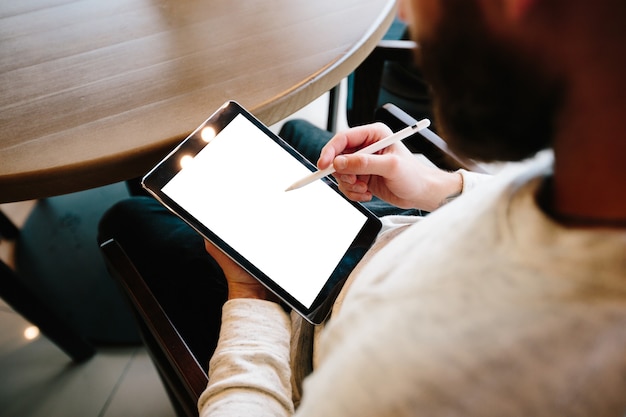 Homme à l'aide de tablet pc avec un crayon à un bureau