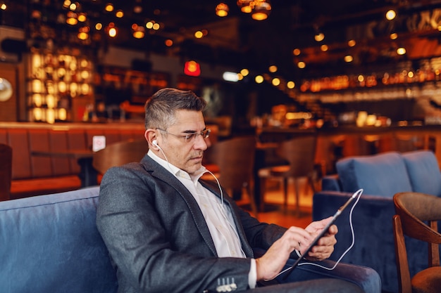 Homme à l'aide de tablette au café.