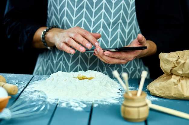 Homme à l'aide de tablette électronique dans la cuisine pour la cuisson.