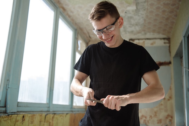 Un homme aiguise un crayon avec un couteau