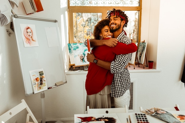 Homme aimant. Aimer bel homme barbu serrant sa belle petite amie aux cheveux noirs bouclés