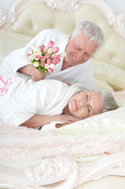 L'homme aîné donne des fleurs à une femme