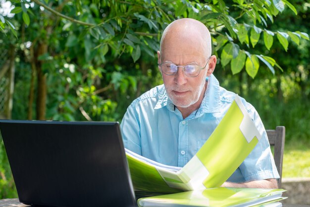 Homme aîné, portable utilisation, dans jardin