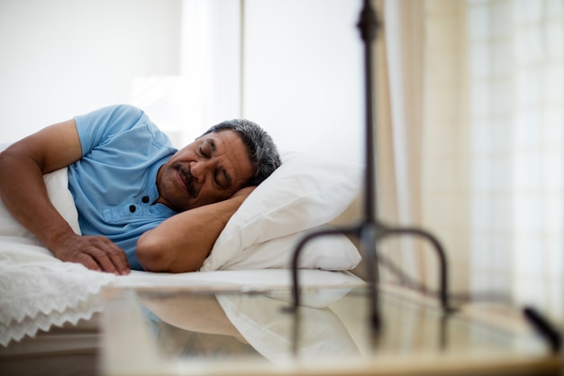 Homme aîné, reposer lit, dans, chambre