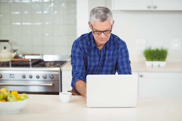 Homme aîné, utilisation, ordinateur portable, dans, cuisine