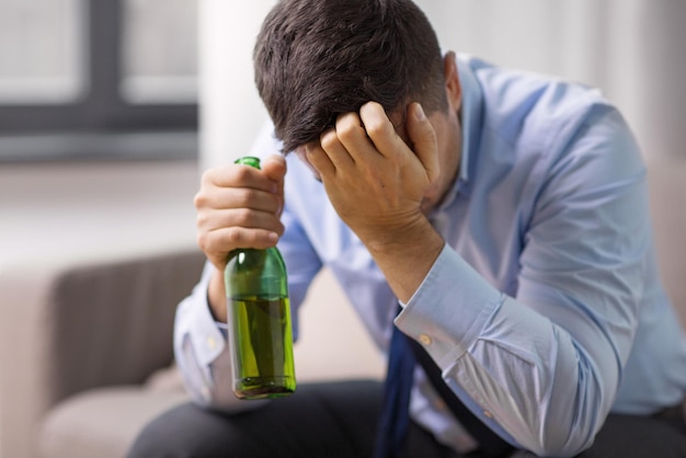 Photo un homme alcoolique buvant de la bière à la maison